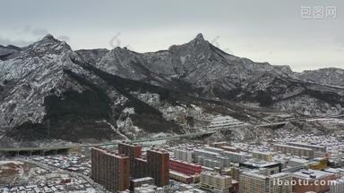 航拍雪后的山峰与城镇城区